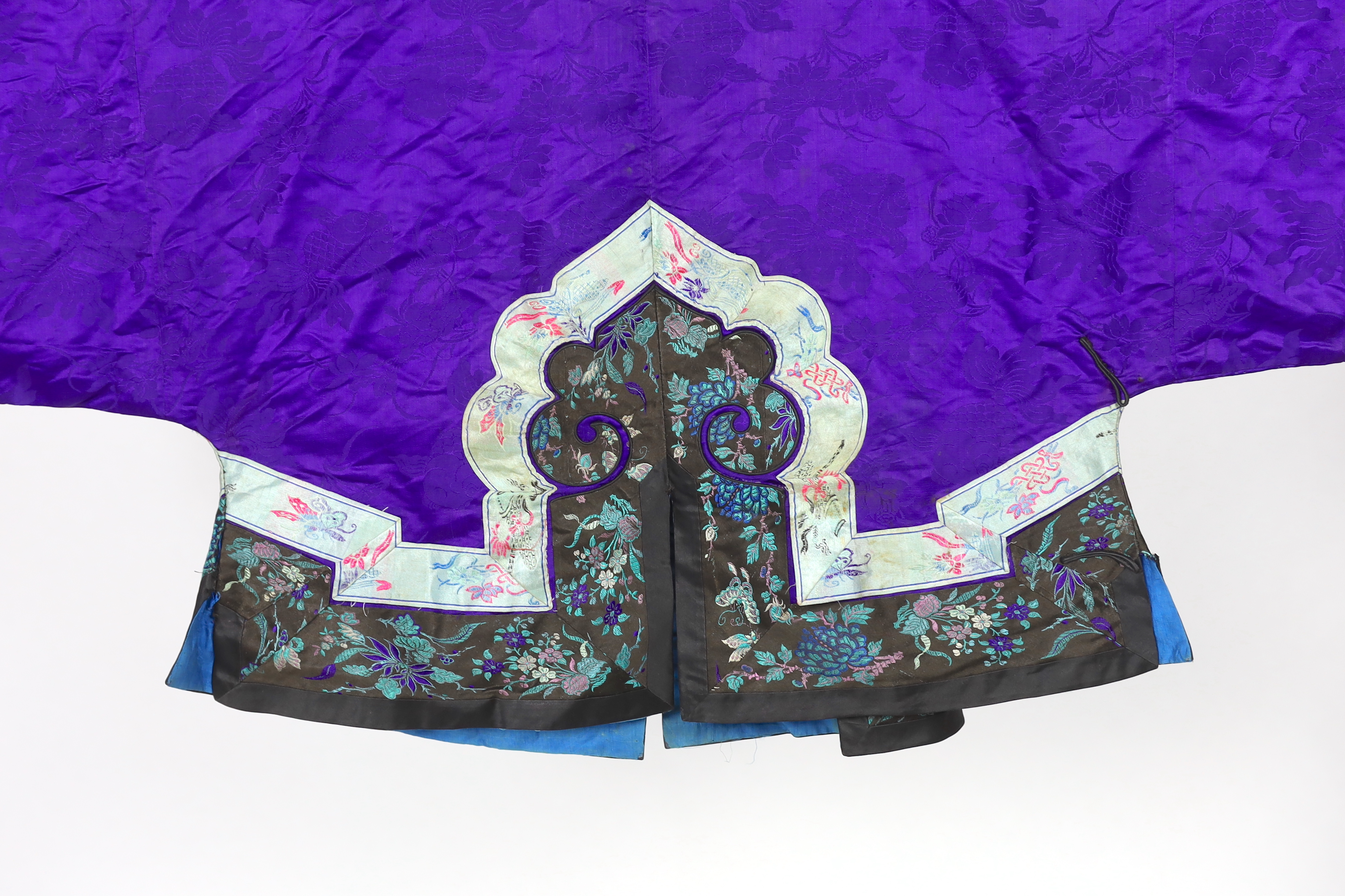 A Chinese purple damask jacket, circa late 19th / early 20th century, decorated with black and turquoise embroidered braiding with auspicious symbols, butterflies and flowers embroidery, 63cm long